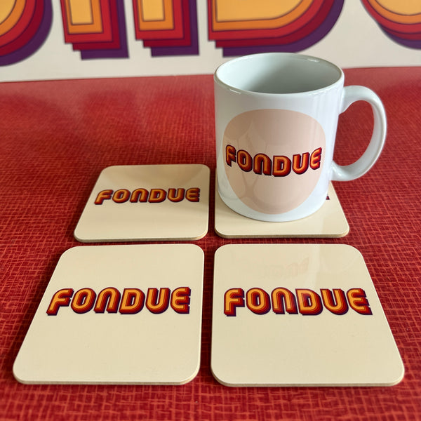 A white ceramic mug and four square coasters, all printed with the word 'FONDUE' in a bold retro red, orange, and yellow gradient font, arranged on a textured red surface.